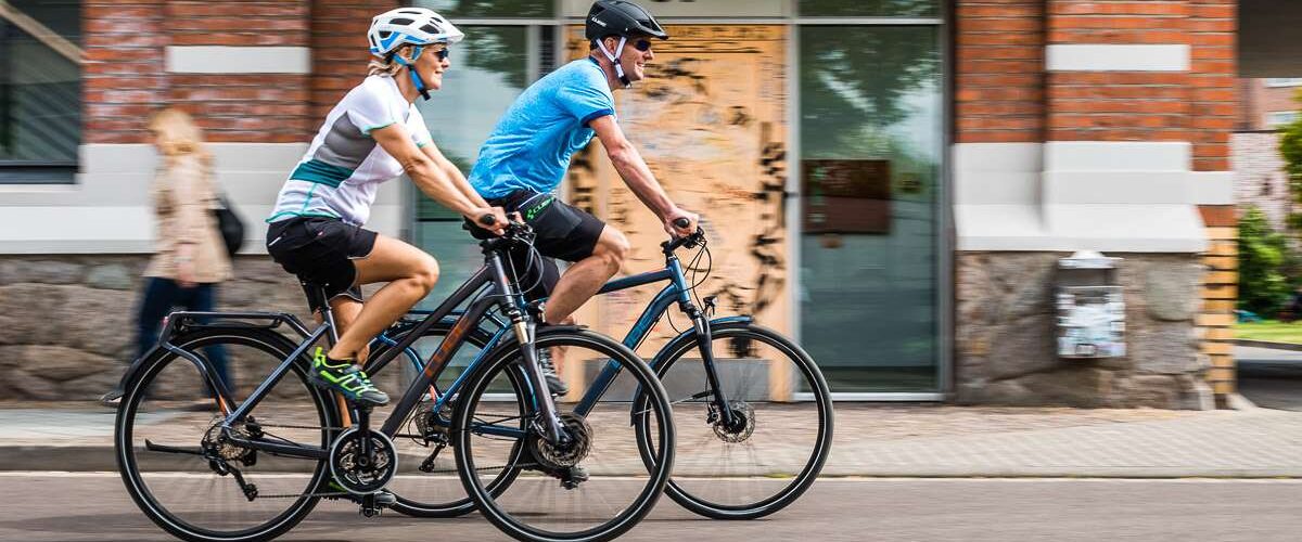 Ein Pärchen fährt auf E-Bikes durch die Stadt.