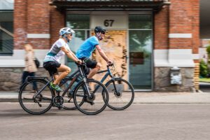 Ein Pärchen fährt auf E-Bikes durch die Stadt.