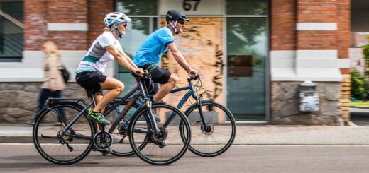 Ein Pärchen fährt auf E-Bikes durch die Stadt.