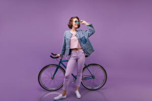 slim blithesome woman posing with bicycle indoor full length shot of curly female model in purple pants 1 300x200 - Schlüssel vom Fahrradschloss oder E-Bike verloren - Was tun?