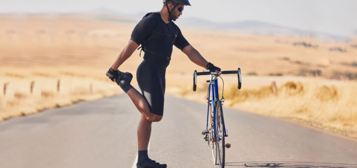 Radfahrer Training - Fahrradfahrer dehnt sich an seinem Fahrrad
