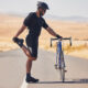 Radfahrer Training - Fahrradfahrer dehnt sich an seinem Fahrrad