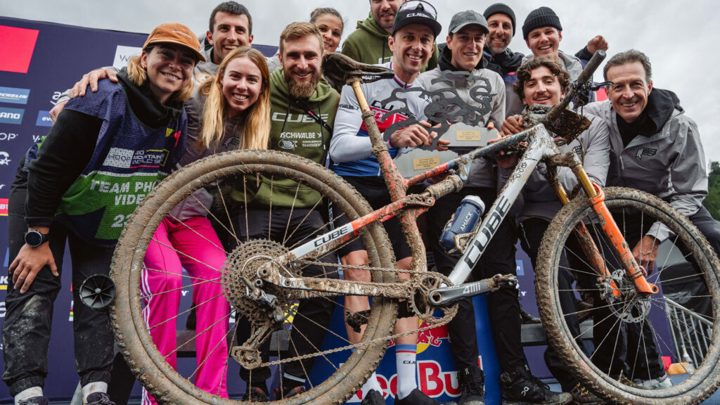 Finn Treudler con la CUBE Fully sporca davanti al podio dopo la sua vittoria U23 XCO a Leogang 2025, insieme al CUBE Factory Racing Team. Finn Treudler con la CUBE Fully sporca davanti al podio dopo la sua vittoria U23 XCO a Leogang 2025, insieme al CUBE Factory Racing Team.