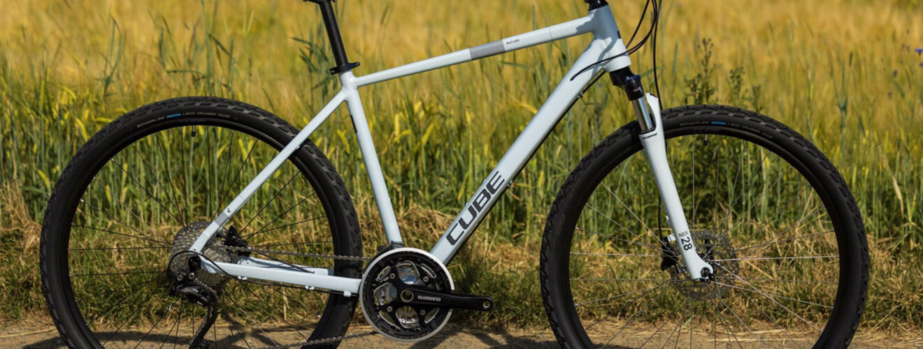 Cube Nature Crossbike auf Feldweg – sportliches Fahrrad vor grün-gelbem Wiesenhintergrund