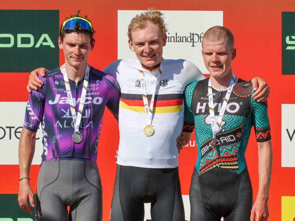 Georg Zimmermann with gold medal embraces the second and third place winners after winning the German Road Cycling Championship 2025