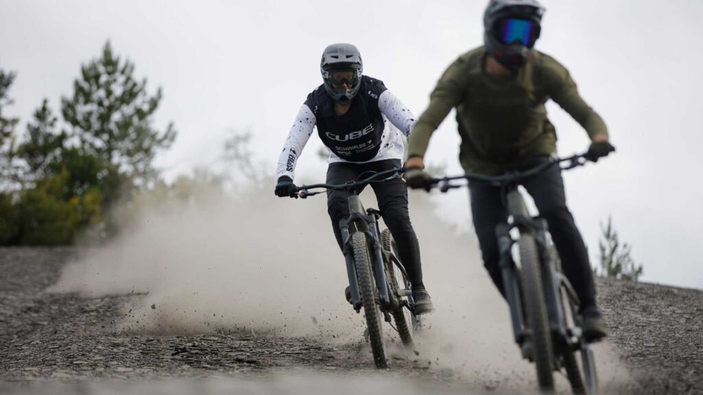 Cube 2026 - cube Fully - zwei Mountainbiker fahren auf steinige untergrund
