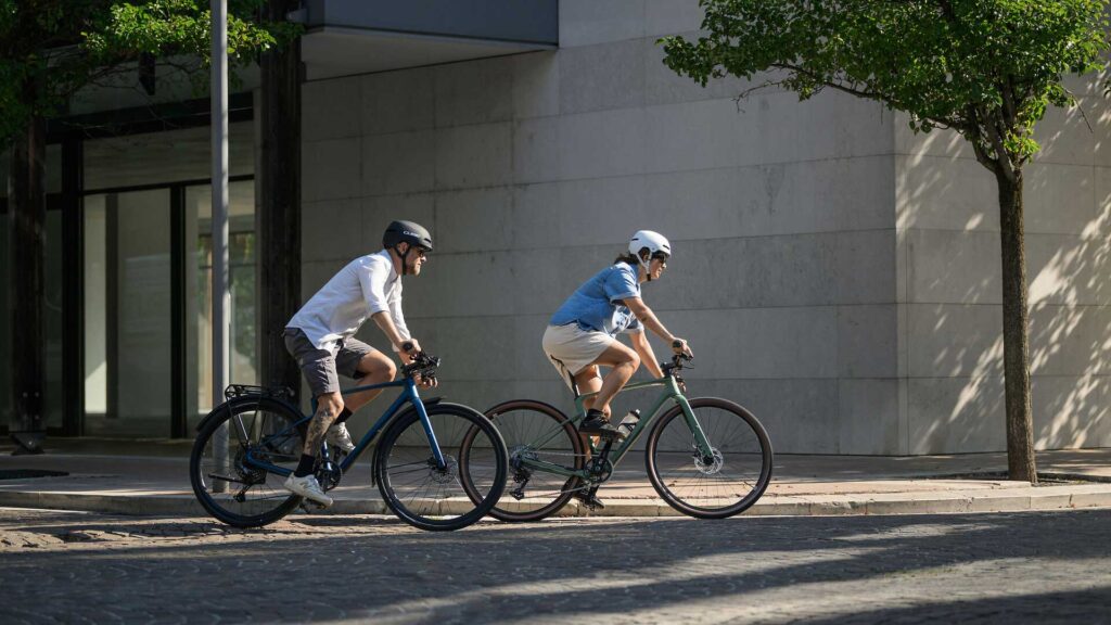 Zwei Radfahrer fahren durch die Stadt mit Ihrem Fitnessräder