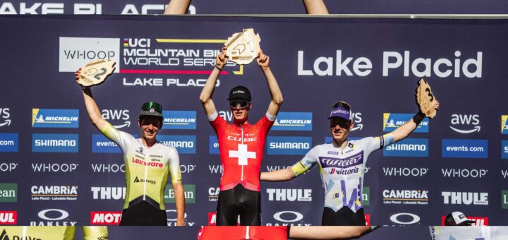 Finn Treudler jubelt auf dem Podium und hält stolz die Trophäe für seinen U23-Triumph in Lake Placid in die Höhe.