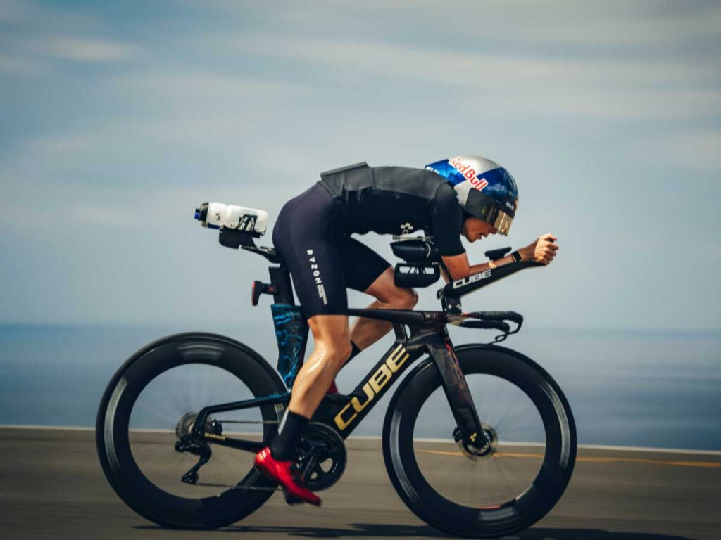 Lucy Charles-Barclay rijdt op haar triatlonfiets tijdens de Ironman Hawaii 2025 en toont volledige concentratie op het fietsonderdeel onder de tropische omstandigheden van Kailua-Kona. Lucy Charles-Barclay rijdt op haar triatlonfiets tijdens de Ironman Hawaii 2025 en toont volledige concentratie op het fietsonderdeel onder de tropische omstandigheden van Kailua-Kona.
